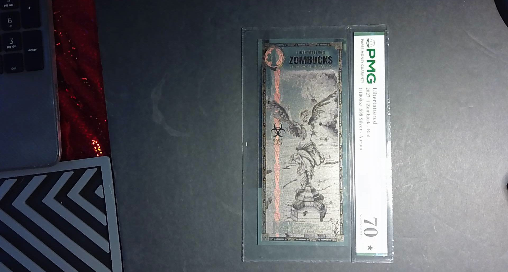 2027 Libertattered 1 Zombuck Red Aurum PMG 70★ – 1/1000 oz .999 Silver
